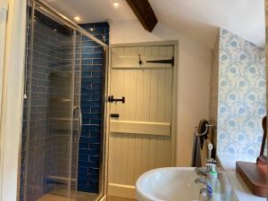 a bathroom with a glass shower and a sink at Glan y Morfa Welsh farmhouse overlooking Dyfi Estuary Rated 4 star Visit Wales in Pennal +41 photos