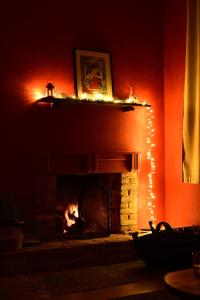 a living room with a fireplace with christmas lights at Toumba Eco Farm Guesthouses in Plomarion