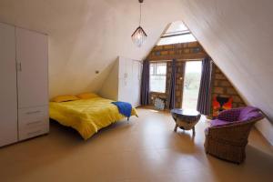una camera da letto con letto e finestra in mansarda di Amboseli Glass house a Oloitokitok 