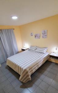 1 dormitorio con 1 cama grande y 2 mesitas de noche en APART CENTER en Villa María