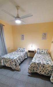 1 dormitorio con 2 camas y ventilador de techo en APART CENTER en Villa María