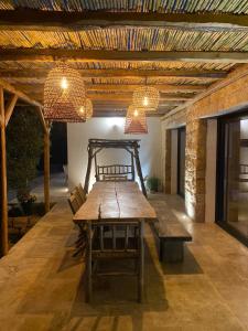 una mesa de madera y un banco en una habitación con luces en Villa de charme avec piscine à Ajaccio, en Alata