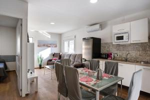 a kitchen and living room with a table and chairs at Casa Rural El Abuelo in Chiclana de la Frontera