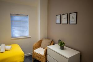 a bedroom with a yellow bed and a chair at Town Street Apartment in Marple +18 photos