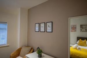 um quarto com um espelho, uma cama e uma cadeira em Town Street Apartment em Marple