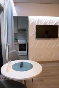 Una sala de estar con una mesa con un control remoto encima. en HighHill Lahti City apartment, en Lahti