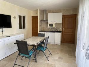 a kitchen with a table and chairs in a room at Villa l'Olivier in Cagnes-sur-Mer +4 photos