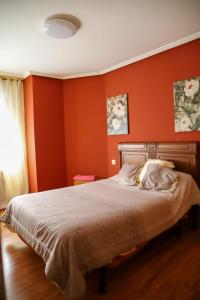 1 dormitorio con paredes rojas y 1 cama grande en Casa MJ, en Béjar