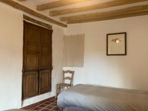 - une chambre avec un lit et une porte en bois dans l'établissement Finca Riolavar, à Jubrique