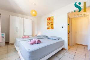 - 2 lits dans une chambre avec des serviettes roses dans l'établissement "Le Cosy", 2 chambres, Centre-ville de Saint-Denis, à Saint-Denis
