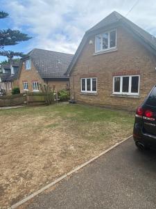 a house with a car parked in front of it at Beautiful 1-Bed Studio in Uxbridge London in Uxbridge