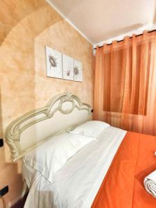 a bedroom with a white bed with an orange curtain at Appartamento Stella in centro a Firenze in Florence