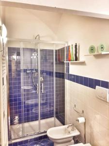 a blue tiled bathroom with a shower and a toilet at Appartamento Stella in centro a Firenze in Florence