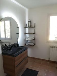 W łazience znajduje się umywalka i lustro. w obiekcie Chez TATA w mieście Régusse