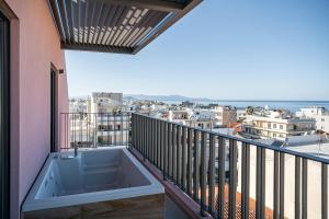 a bath tub on a balcony with a view of a city at Sea & Sun Penthouse in Chania