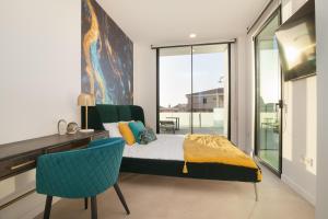 um quarto com uma cama, uma secretária e uma cadeira em 200m NEW A Villa with private, heated pool and amazing ocean view em Adeje