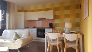 ein Wohnzimmer mit einer Couch und einem Tisch mit Stühlen in der Unterkunft Ferienwohnungen Brasse in Dornumersiel
