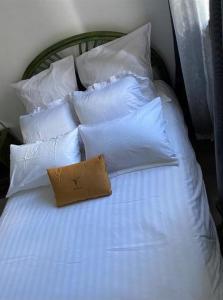 a white bed with white pillows and a pillow on it at Chambre Cosy et Chambre Sam WIFI PARKING GRATUIT in Rosny-sous-Bois