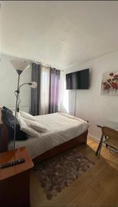 a bedroom with a bed and a lamp and a table at Chambre Cosy et Chambre Sam WIFI PARKING GRATUIT in Rosny-sous-Bois
