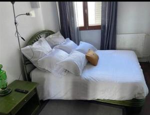 a white bed with white pillows and a window at Chambre Cosy et Chambre Sam WIFI PARKING GRATUIT in Rosny-sous-Bois