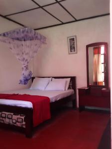 een slaapkamer met een bed met een spiegel en een bed sidx sidx sidx bij Lily adam's peak in Nallathanniya