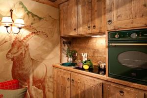 una cocina con una pintura de una cabra en la pared en La Petite, en Courmayeur