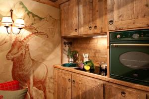 a kitchen with a painting of a goat on the wall at La Petite in Courmayeur