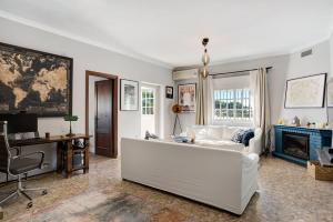 Una sala de estar con un sofá blanco y una chimenea. en Villa Paraíso, en Pago del Humo