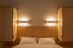 - une chambre avec deux lumières sur la tête du lit dans l'établissement Une chambre à l'Economat, à Bordeaux