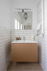 ein Bad mit einem Waschbecken und einem Spiegel in der Unterkunft Gold Medals Flat in Rom