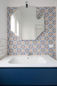 La salle de bains est pourvue d'un lavabo blanc et d'un miroir. dans l'établissement Gold Medals Flat, à Rome