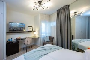 um quarto de hotel com uma cama, uma secretária e uma televisão em Maxim Design Hotel 3 Star Superior em Tel Aviv