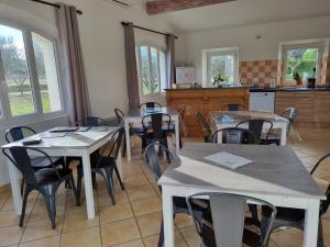 cocina y comedor con mesas y sillas en La Fanette en Montbrison-sur-Lez