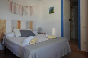 ein Schlafzimmer mit einem großen weißen Bett mit zwei Kissen in der Unterkunft Casa rural Cal Gasso in El Poble Nou del Delta