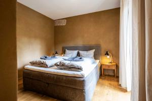 a bedroom with a large bed with white sheets at SEINZ Wisdom Resort - Bio-Hotel vegan-vegetarisch in Bad Kohlgrub