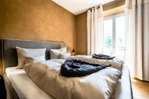 a bedroom with two beds and a large window at SEINZ Wisdom Resort - Bio-Hotel vegan-vegetarisch in Bad Kohlgrub