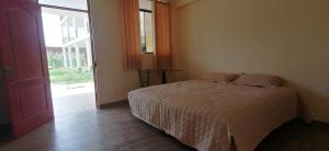 1 dormitorio con cama y ventana grande en Catalina Huanca Resort, en San Jerónimo