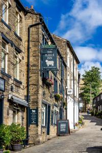 a brick building with a sign on it on a street at The Fleece Inn in Haworth