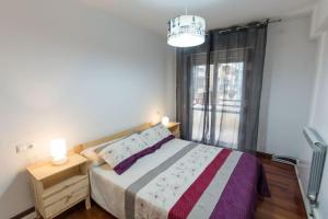 a bedroom with a bed and a large window at APARTAMENTO DANAE centro in Zumaia