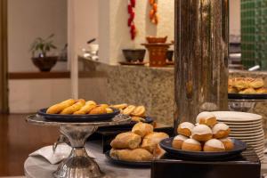 a buffet with plates of pastries on a table at Hotel Guadalajara Plaza Expo in Guadalajara