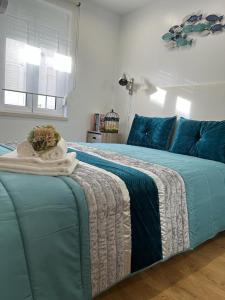 een slaapkamer met een groot bed met blauwe kussens bij Camarote Beach in Nazaré