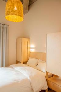 - une chambre avec un lit blanc et une lampe dans l'établissement Une chambre à l'Economat, à Bordeaux