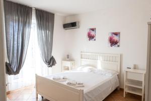 a bedroom with a white bed and a large window at Gambero Nero in Tellaro