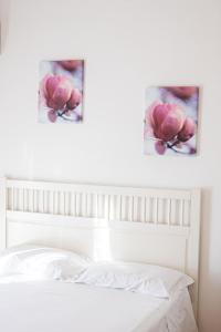 two paintings of pink flowers above a bed at Gambero Nero in Tellaro