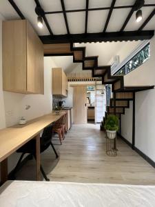 an open kitchen with wooden cabinets and a long table at Mini Casa en Poblado Medellín FRN109 By Roots Rentals in Medellín
