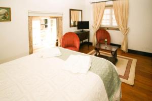 a bedroom with a bed and a desk and a window at Quinta de Malta in Durrães