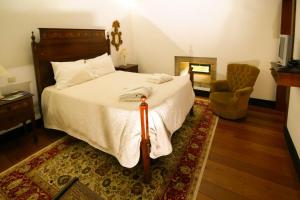 a bedroom with a large bed and a chair at Quinta de Malta in Durrães