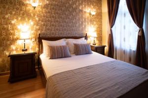 a bedroom with a bed with two lamps and a window at Hotel Europa in Târgu Jiu