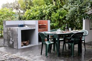 a table and chairs with a table and a fireplace at Casa Cor de Rosa in Madalena