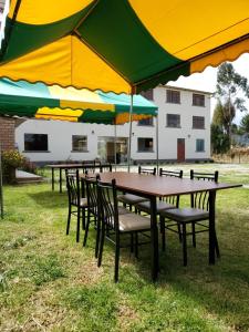 un grupo de mesas y sillas con sombrillas en Catalina Huanca Resort, en San Jerónimo